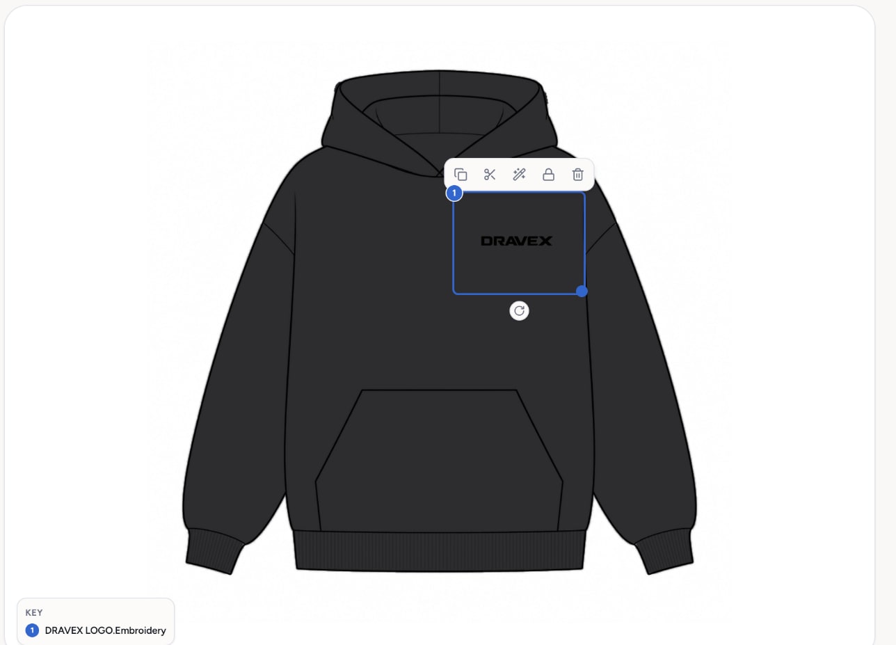 The DRAVEX logo selected on the black hoodie canvas with its resize handles and a small toolbar for copy, cut-out, wand, lock and delete